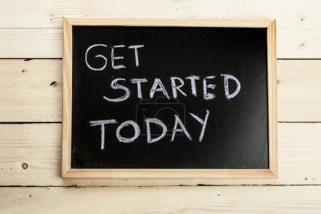 Photo for Black chalkboard on wooden background with the inscription: "get started today" - Royalty Free Image