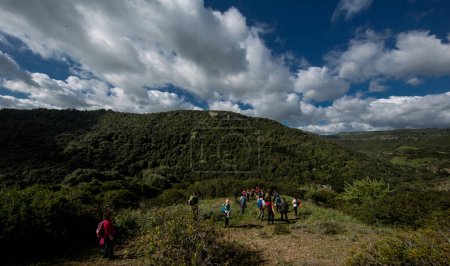 Téléchargez les photos : Groupe de randonneurs promenades dans les montagnes entourées par la nature - en image libre de droit