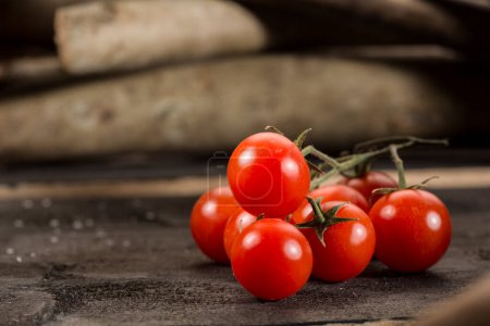 Foto de Ramo de tomates descansando sobre una mesa de madera - Imagen libre de derechos