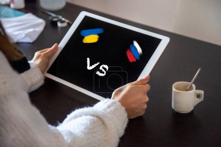 Téléchargez les photos : Femme tient ordinateur portable avec Ukraine VS drapeau russe à l'écran - en image libre de droit