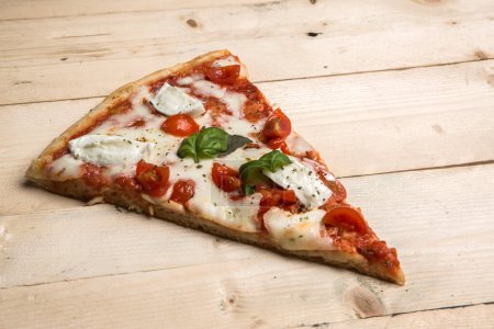 Foto de Detalle de una pizza con tomates, mozzarella y albahaca - Imagen libre de derechos