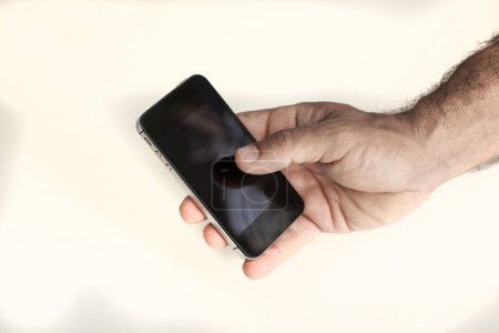 Téléchargez les photos : Main d'homme tenant un smartphone, gros plan. - en image libre de droit