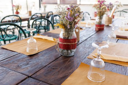 Foto de Mesa con flores y vasos para la cena en restaurante - Imagen libre de derechos