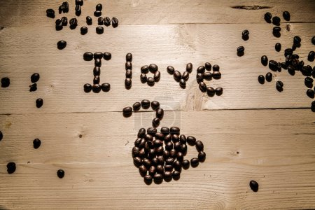 Téléchargez les photos : Écrit avec des grains de café "J'aime le café" sur une table en bois - en image libre de droit