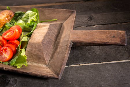 Téléchargez les photos : Savoureuse salade fraîche aux tomates et laitue sur planche de bois - en image libre de droit