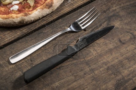Photo for Close-up view of fresh pizza and fork with knife on wooden background - Royalty Free Image
