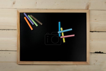 Téléchargez les photos : Vue de dessus de craies colorées sur un tableau noir - en image libre de droit