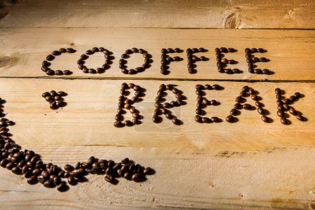 Foto de Escrito "coffee break" en tablas de madera con granos de café - Imagen libre de derechos