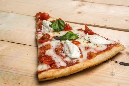 Téléchargez les photos : Détail d'une pizza aux tomates, mozzarella et basilic - en image libre de droit