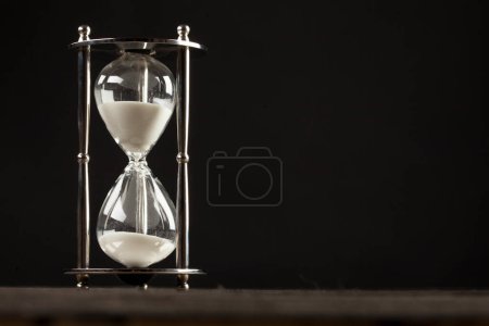 Photo for Hourglass with white sand on a black background - Royalty Free Image