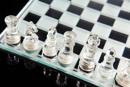 Foto de Ajedrez de vidrio en el tablero de ajedrez se reflejan en la superficie oscura - Imagen libre de derechos