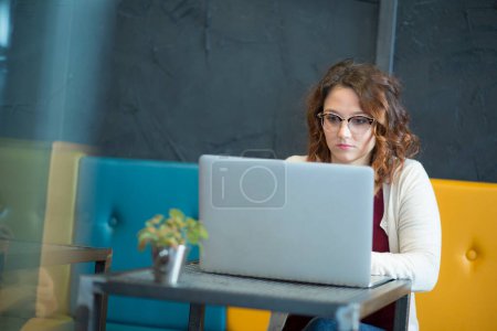 Téléchargez les photos : Belle jeune femme travaillant avec un ordinateur portable - en image libre de droit