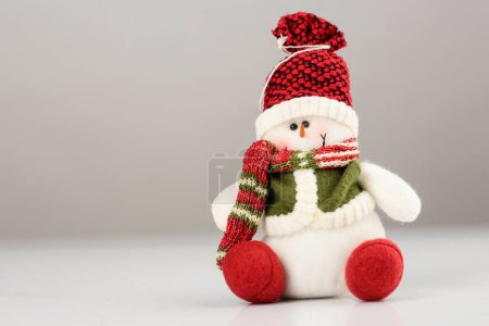 Foto de Muñeco de nieve en sombrero de Navidad sobre fondo gris - Imagen libre de derechos