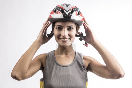 Foto de Mujer ciclista sonriente en el casco técnico, aislada sobre fondo claro - Imagen libre de derechos