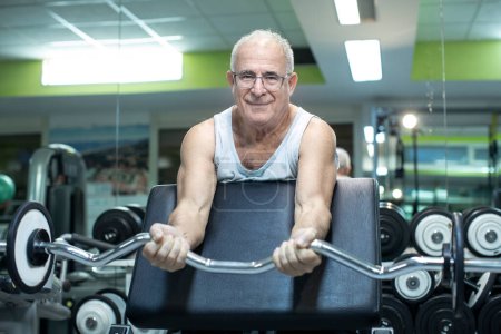 Foto de Hombre mayor haciendo ejercicio en el gimnasio - Imagen libre de derechos