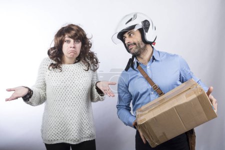Photo for Courier with helmet makes delivery of a parcel to an amazed lady, isolated on white background - Royalty Free Image