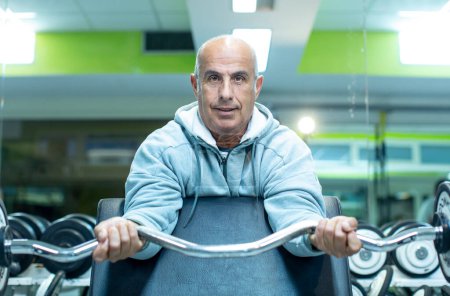 Photo for Mature man doing exercises in gym - Royalty Free Image
