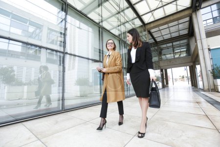 two businesswomen on street near business building-stock-photo