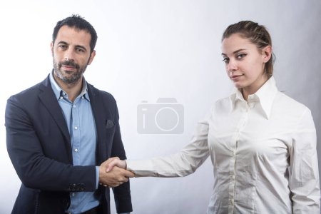Photo for Blonde woman in white shirt holds out a man in jacket as a sign of agreement isolated on white background - Royalty Free Image