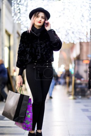 Foto de Hermosa mujer con el pelo castaño pintado de púrpura alrededor de las tiendas para ir de compras - Imagen libre de derechos