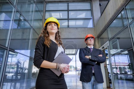 Photo for Engineers with hard hat in modern urban setting - Royalty Free Image