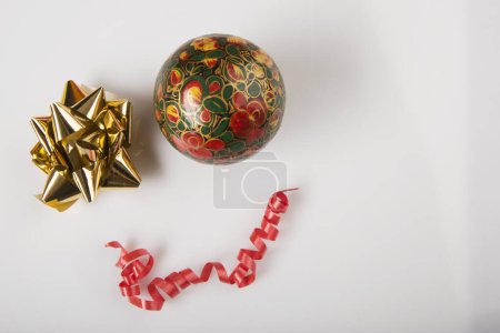Téléchargez les photos : Cadeau rouge avec ruban doré et œufs dorés sur blanc - en image libre de droit