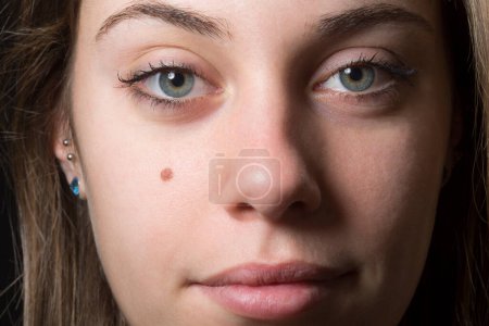 Foto de Retrato cercano de hermosa chica rubia con ojos verdes aislados sobre fondo negro - Imagen libre de derechos