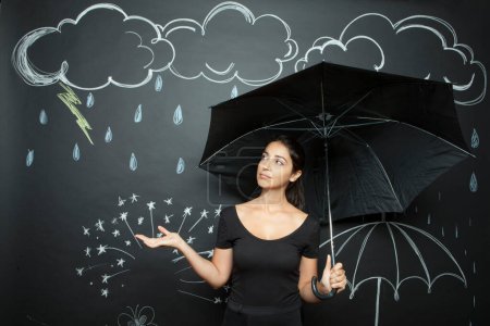 Téléchargez les photos : Femme tenant un parapluie vert isolé sur noir - en image libre de droit