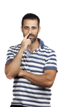 Photo for Man with white and blue t-shirt put his finger into his nose in a white background - Royalty Free Image