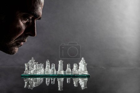 Téléchargez les photos : Homme d'affaires avec des pièces d'échecs en arrière-plan - en image libre de droit