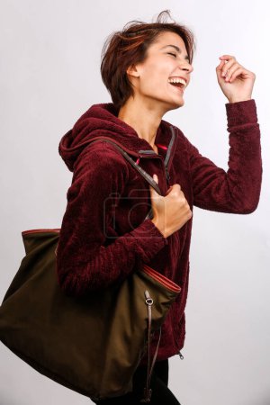 Téléchargez les photos : Belle fille avec sac s'amuse isolé sur fond blanc - en image libre de droit