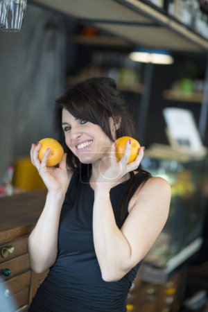 Téléchargez les photos : Femme tenant du jus d'orange dans la cuisine - en image libre de droit
