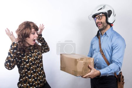 Photo for Courier with helmet makes delivery of a parcel to an amazed lady, isolated on white background - Royalty Free Image