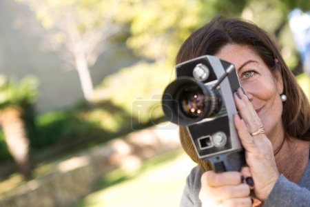 Foto de Señora se divierte en un parque usando una vieja cámara de película analógica - Imagen libre de derechos