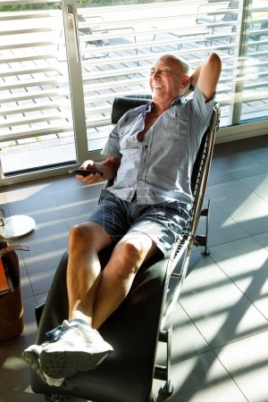 Foto de Setenta años anciano se relaja en un sillón en su sala de estar - Imagen libre de derechos