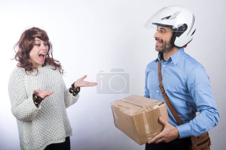 Foto de Mensajero con casco hace la entrega de un paquete a una dama feliz, aislado sobre fondo blanco - Imagen libre de derechos