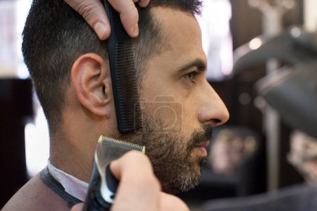Téléchargez les photos : Un coiffeur qui coupe les cheveux d'un homme - en image libre de droit