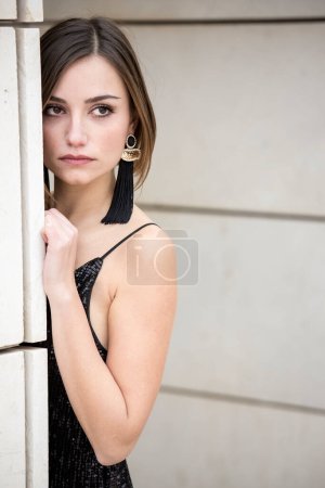 Photo for Beautiful girl with bob hair and a short black dress with suspenders - Royalty Free Image