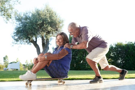 Foto de Pareja de personas mayores divertirse con monopatín - Imagen libre de derechos