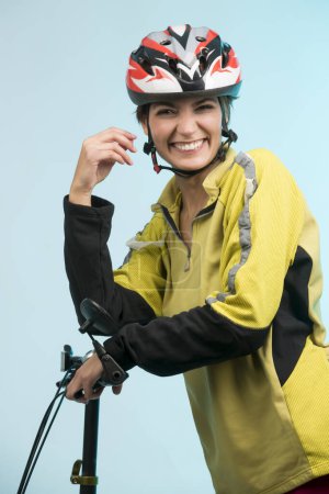 Photo for Smiling girl with helmet on her head and her bike, isolated on neutral background - Royalty Free Image