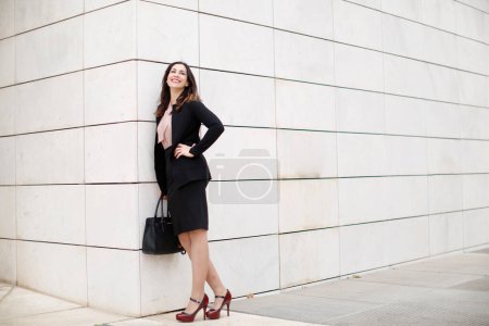 Téléchargez les photos : Brunette femme manager, habillée en costume d'affaires noir - en image libre de droit