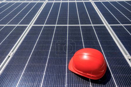 Foto de Paneles fotovoltaicos con casco protector de un trabajador - Imagen libre de derechos