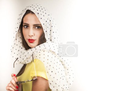 Photo for Blonde girl with head scarf and yellow shirt dressed 50's style is isolated on gray background - Royalty Free Image