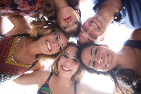 Téléchargez les photos : Groupe d'amis souriants dans le cercle - vue du bas - en image libre de droit