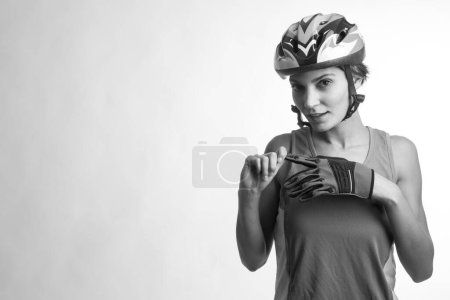 Téléchargez les photos : Femme cycliste dans le casque technique, isolée sur fond clair, noir et blanc - en image libre de droit