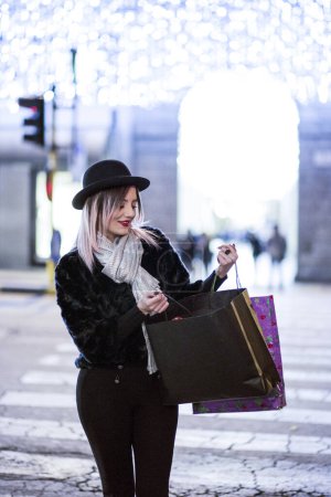 Foto de Hermosa mujer con el pelo castaño pintado de púrpura alrededor de las tiendas para ir de compras - Imagen libre de derechos
