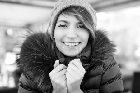 Foto de Retrato de hermosa chica sonriente con gorra y abrigo, blanco y negro - Imagen libre de derechos