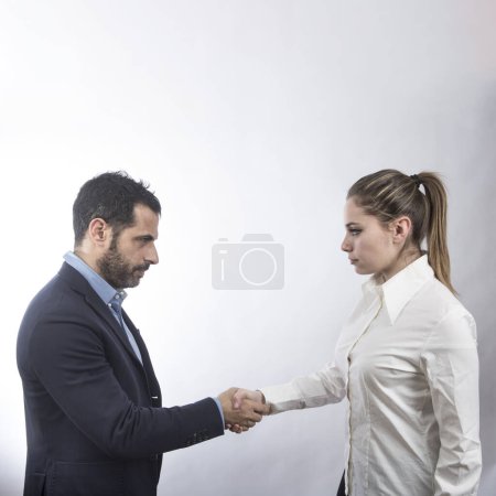 Téléchargez les photos : Femme blonde en chemise blanche tend un homme en veste comme un signe d'accord isolé sur fond blanc - en image libre de droit