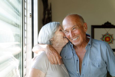 Téléchargez les photos : Heureux couple senior baisers et câlins à la maison - en image libre de droit