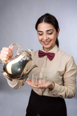 Photo for Waitress serves tea in a small cup - Royalty Free Image